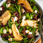 Overhead view of bowl of Pear Salad with forks, glass of white wine and loaf of bread beside - 10