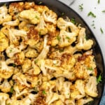 pinterest graphic of overhead of a plate of air fried cauliflower sprinkled with parsley, says "air fryer cauliflower recipe simplejoy.com"