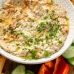 Pinterest graphic for Baba Ganoush recipe. Image shows bowl of Baba Ganoush garnished with parsley, surrounded by chopped vegetables and pita chips. Text says, "super easy Baba Ganoush simplejoy.com."