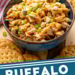 Pinterest graphic for Buffalo Chicken Salad recipe. Image shows a bowl of Buffalo Chicken Salad garnished with blue cheese crumbles and chopped green onions, crackers beside. Text says, "Buffalo Chicken Salad simplejoy.com."