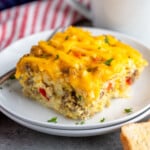 Pinterest graphic for Hashbrown Breakfast Casserole recipe. Image shows plate with piece of Hashbrown Breakfast Casserole, cup of coffee beside. Text says, "Hashbrown Breakfast Casserole simplejoy.com."