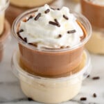 Pinterest graphic for Pudding Shots recipe. Image shows stacks of Pudding Shots garnished with whipped cream and sprinkles. Text says, "super easy Pudding Shots simplejoy.com."