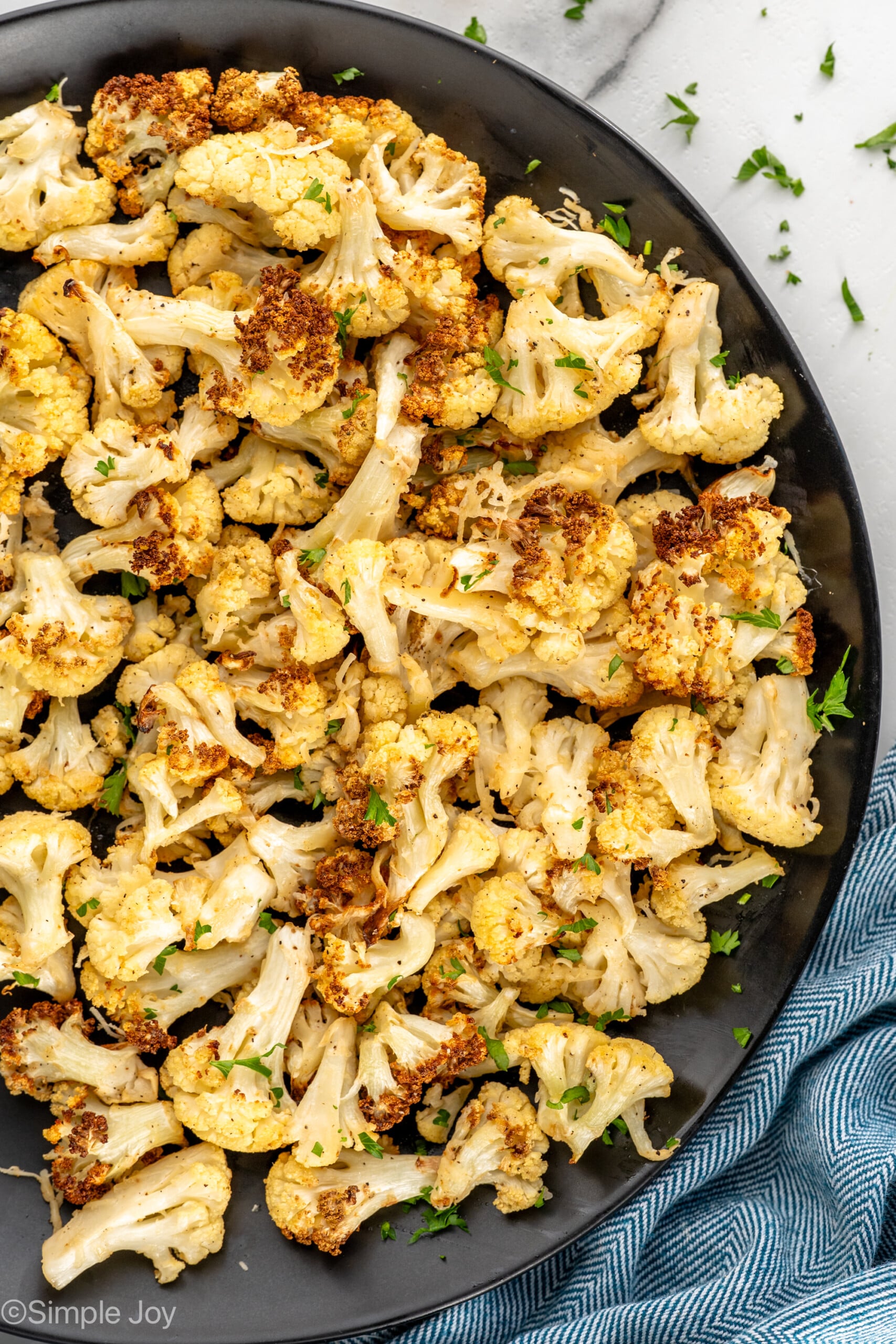 overhead of a plate of air fried cauliflower sprinkled with parsley