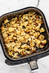 overhead of air fried cauliflower in the basket of the air fryer - 10