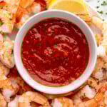 Overhead view of a platter of shrimp and lemon wedge with a bowl of Shrimp Cocktail Sauce - 8
