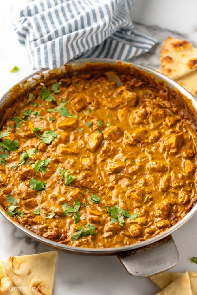 Skillet of Chicken Curry garnished with cilantro with naan bread beside - 8
