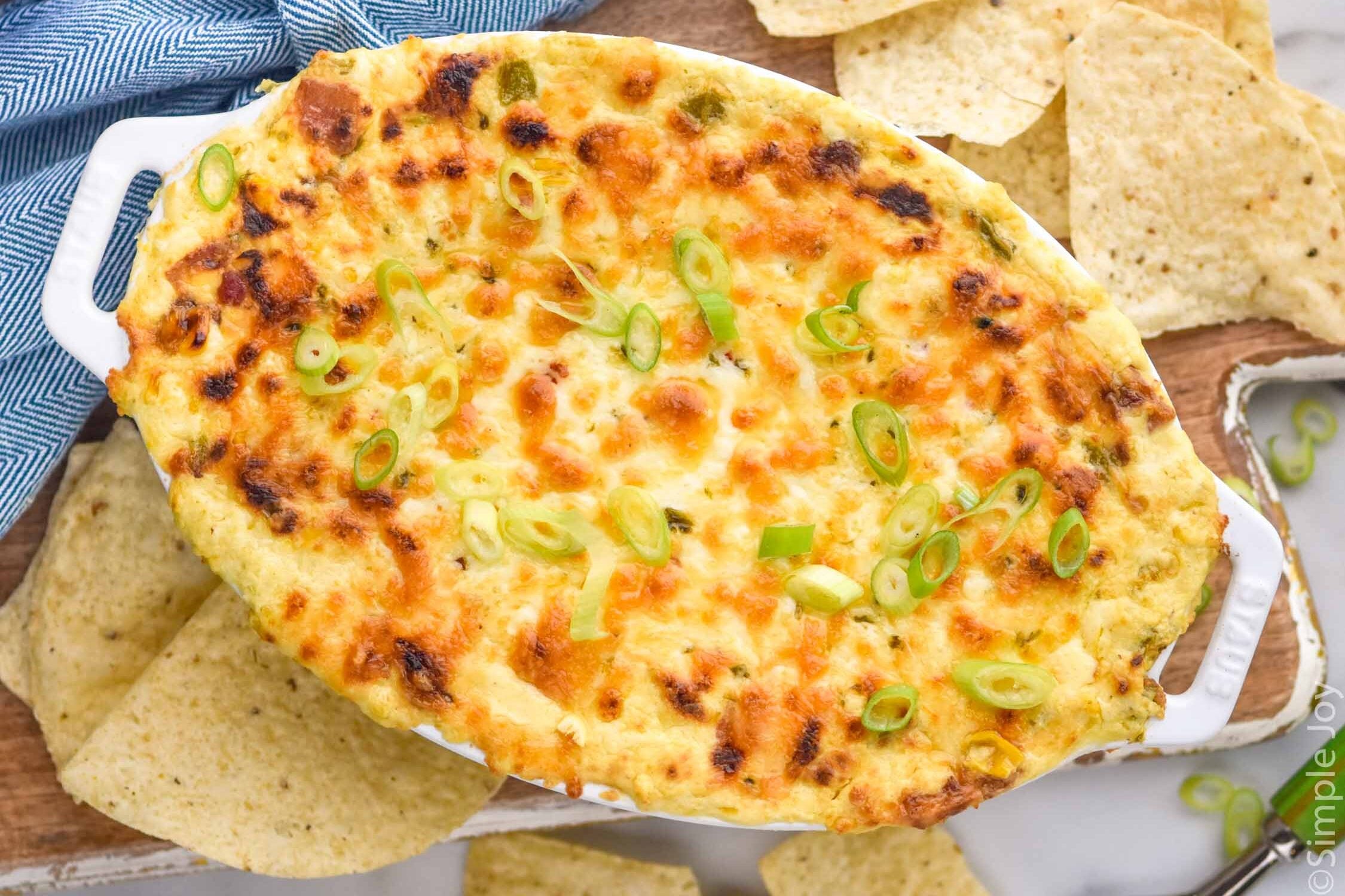 overhead of dish of hot corn dip surrounded by tortilla chips