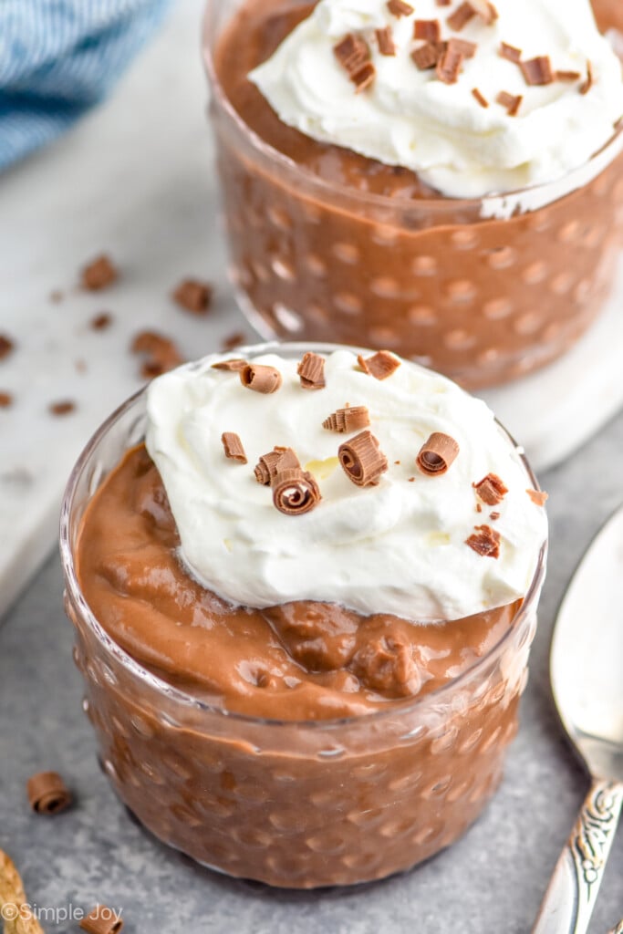 close up of a small cup of chocolate pudding recipe filled topped with whipped cream and chocolate shavings - 4
