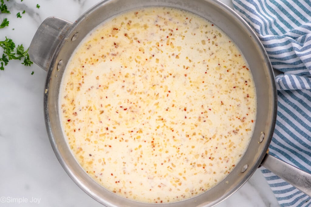 Overhead view of skillet of sauce ingredients for Mussels recipe. - 7
