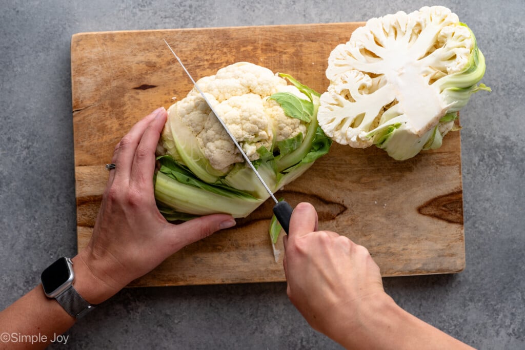 Overhead view of person's hand cutting up head of cauliflower - 3