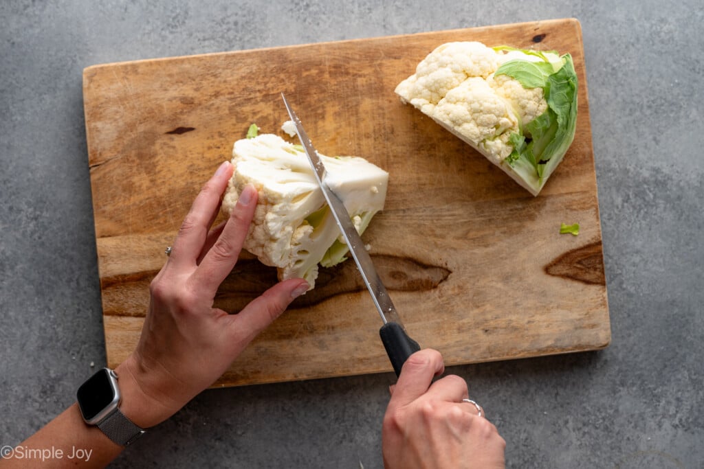 Overhead view of person's hands cutting up head of cauliflower - 4