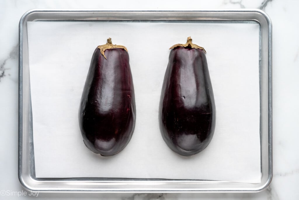 Overhead view of a lined baking sheet with eggplant for Baba Ganoush recipe - 5