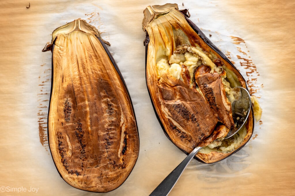 Overhead view of roasted eggplant with a spoon for scooping for Baba Ganoush recipe - 6