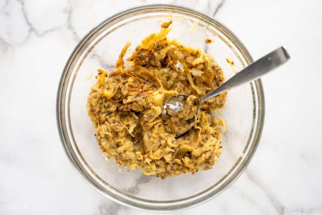 Overhead view of a mixing bowl with ingredients and a spoon for Baba Ganoush recipe - 7