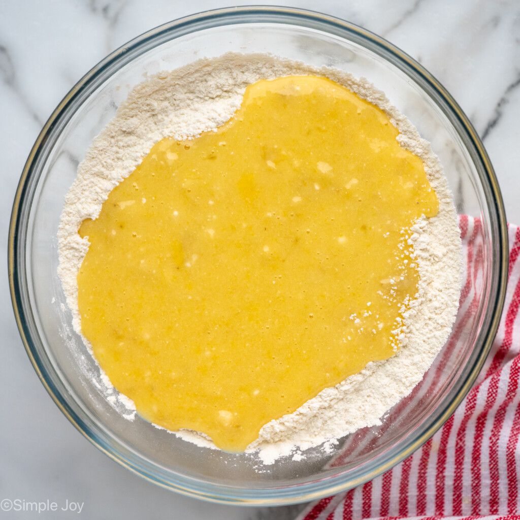 Overhead view of mixing bowl of wet and dry ingredients for banana chocolate chip muffins recipe - 9