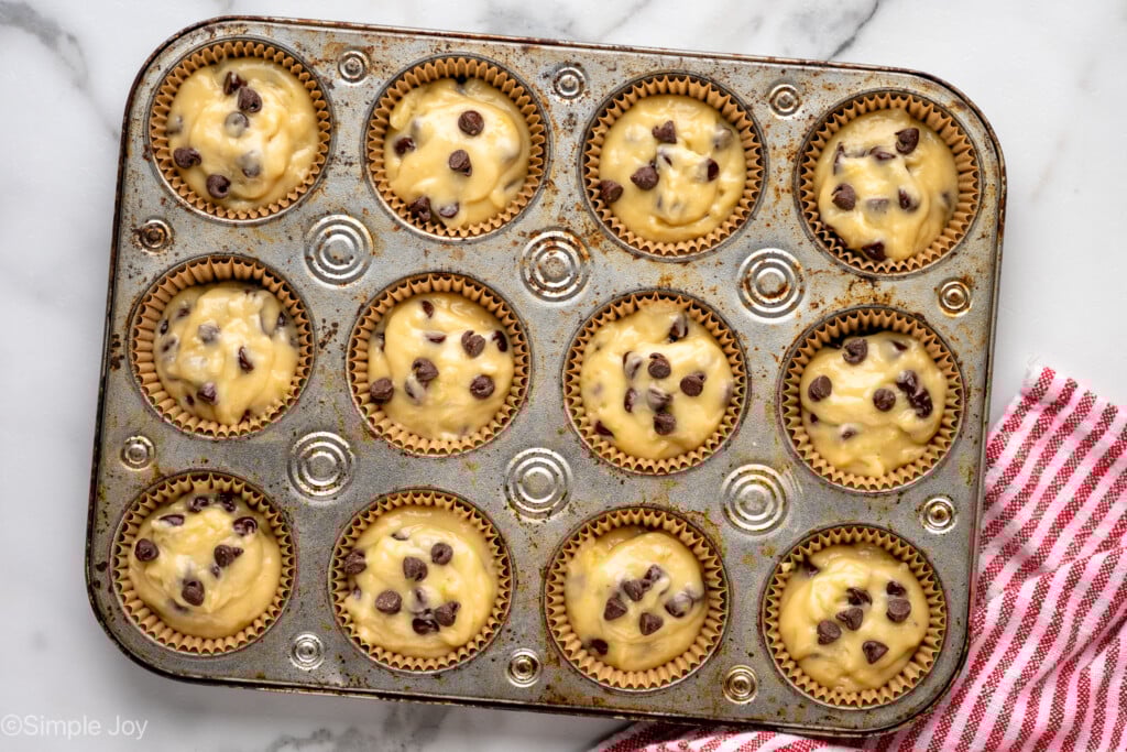 Overhead view of a muffin tin with banana chocolate chip muffins recipe before baking - 11