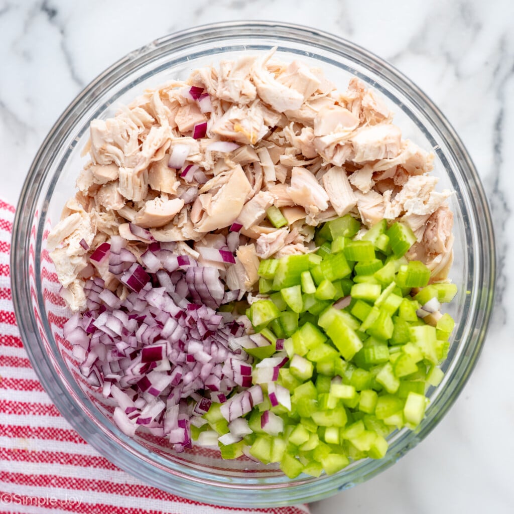 Overhead view of a glass mixing bowl of ingredients for Buffalo Chicken Salad recipe. - 7
