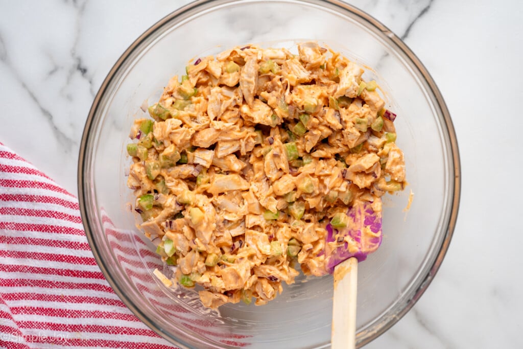 Overhead view of a mixing bowl of ingredients with a spatula for Buffalo Chicken Salad recipe - 9