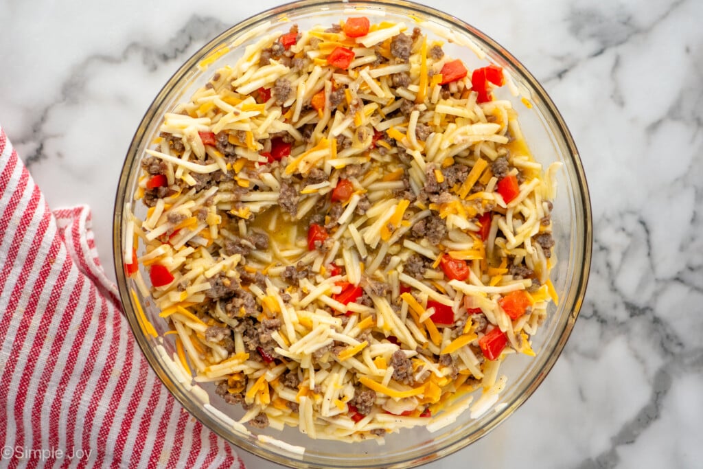 Overhead view of a mixing bowl of ingredients combined for Hashbrown Breakfast Casserole recipe - 10