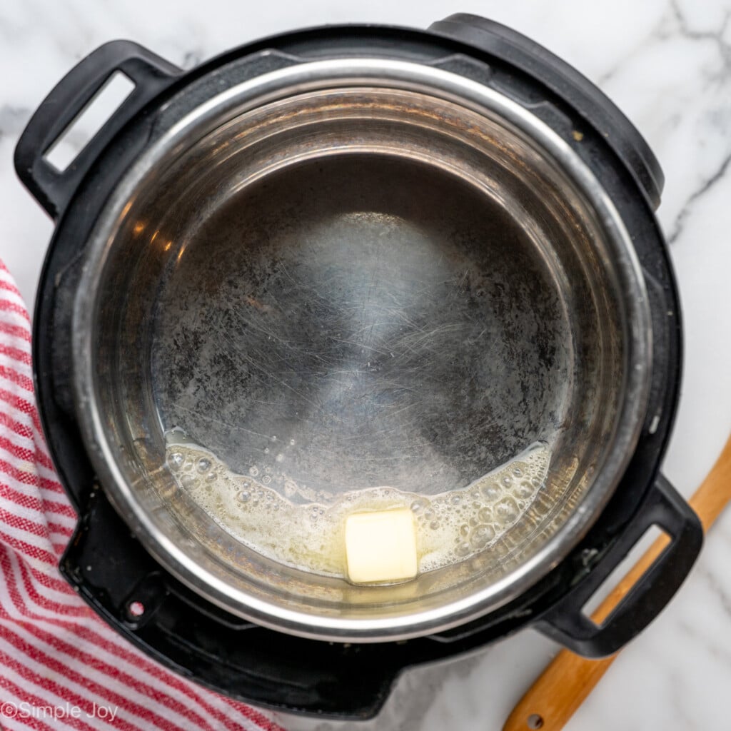 Overhead view of instant pot with butter for Instant Pot Steel Cut Oats recipe - 6