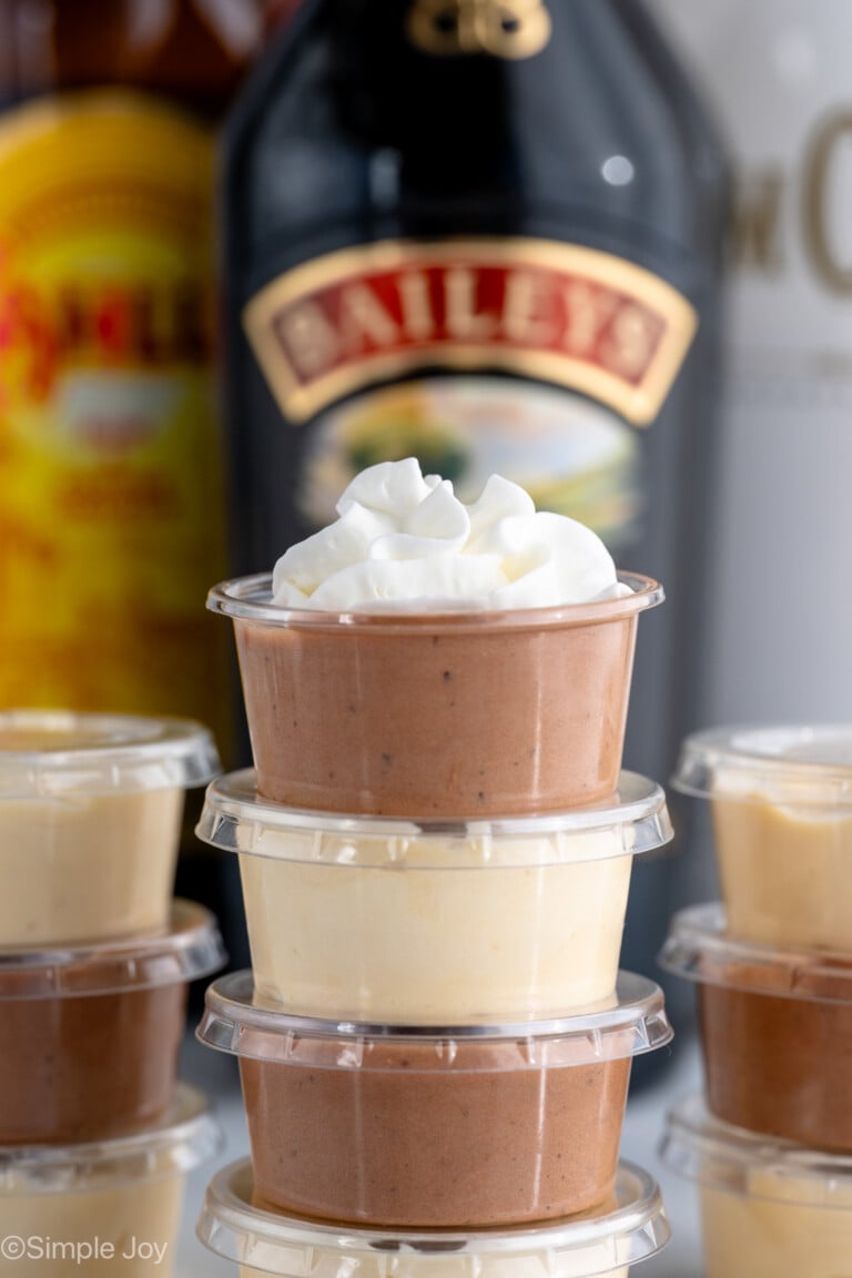 Side view of stack of Pudding Shots with topped Pudding Shot garnished with whipped cream