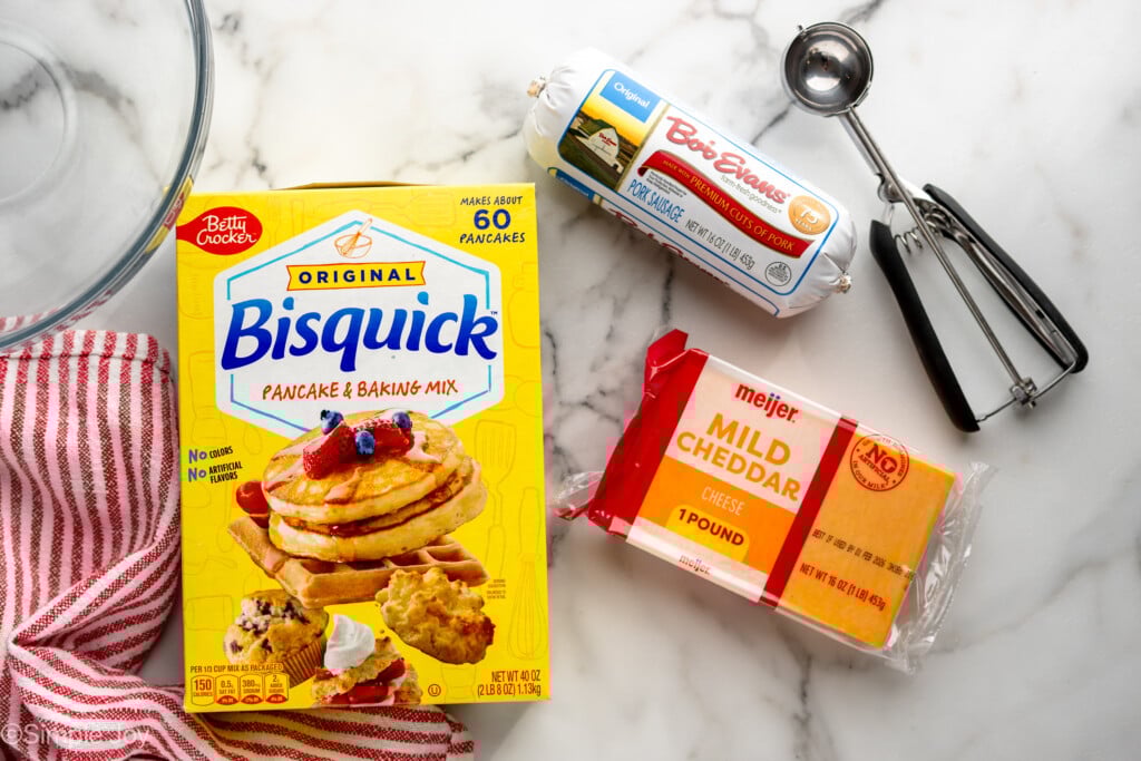 Overhead view of ingredients for Sausage Balls recipe on countertop with cookie scooper. - 5