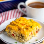 Piece of Hashbrown Breakfast Casserole served on a plate with a fork, cup of coffee beside. - 15