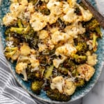 Pinterest graphic for Roasted Broccoli and Cauliflower recipe. Overhead view of a platter of Roasted Broccoli and Cauliflower with parmesan cheese, forks beside. Text says, "Roasted Broccoli and Cauliflower simplejoy.com."