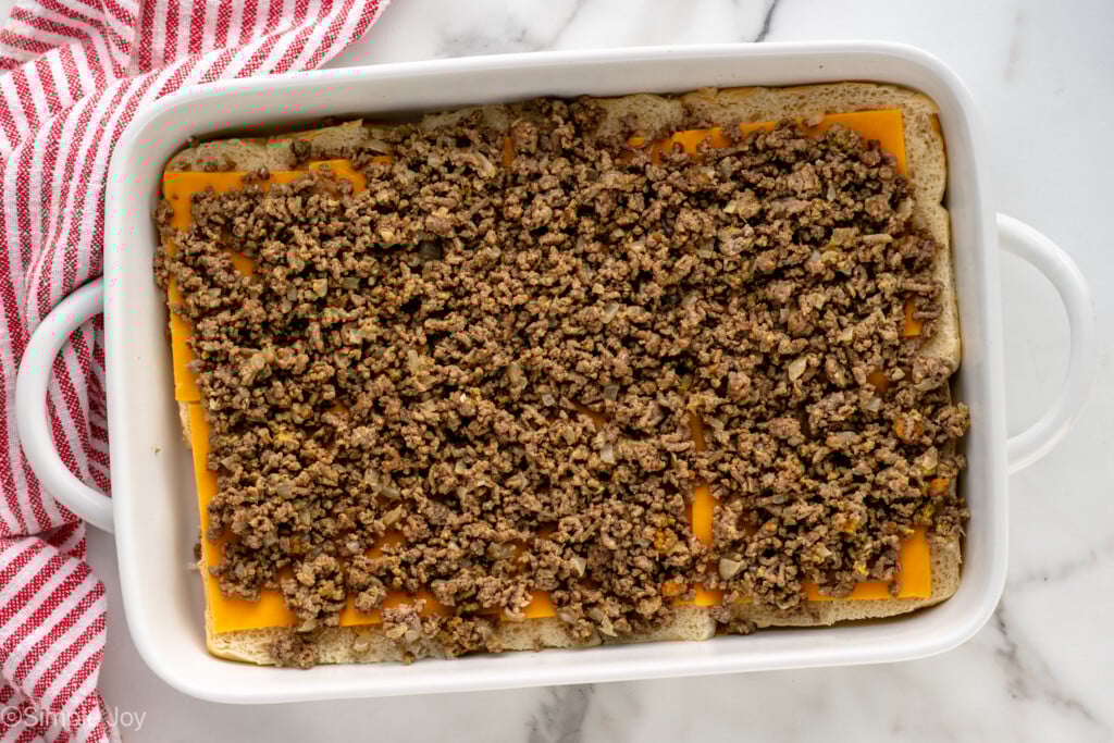 Overhead view of a baking dish of hamburger layer of Cheeseburger Sliders recipe - 8