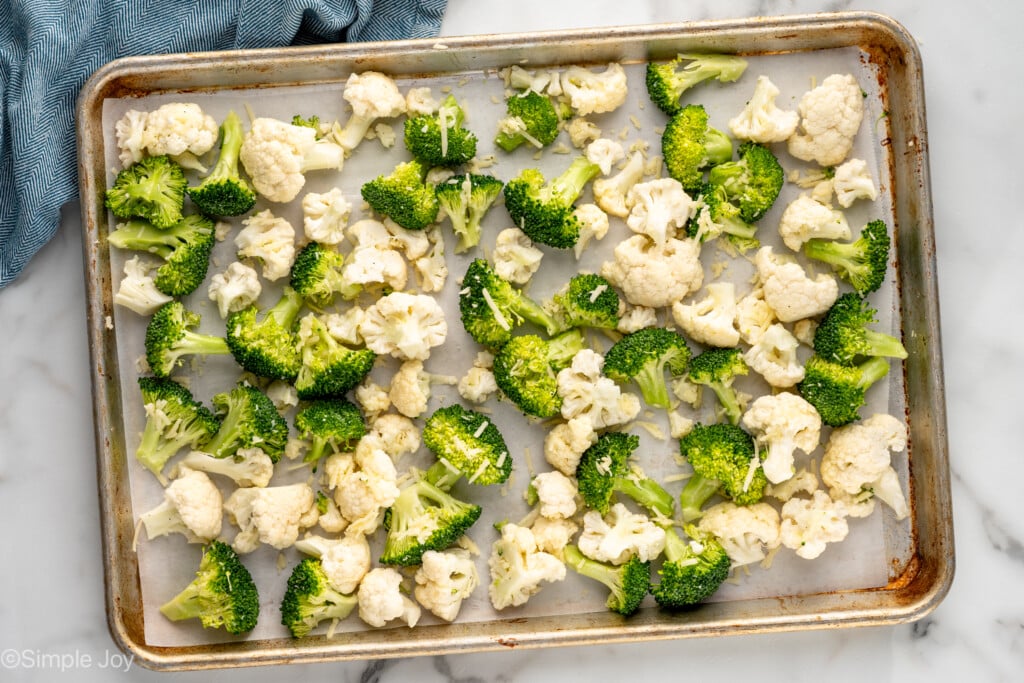 Overhead view of a baking sheet of broccoli and cauliflower before baking for Roasted Broccoli and Cauliflower recipe - 5