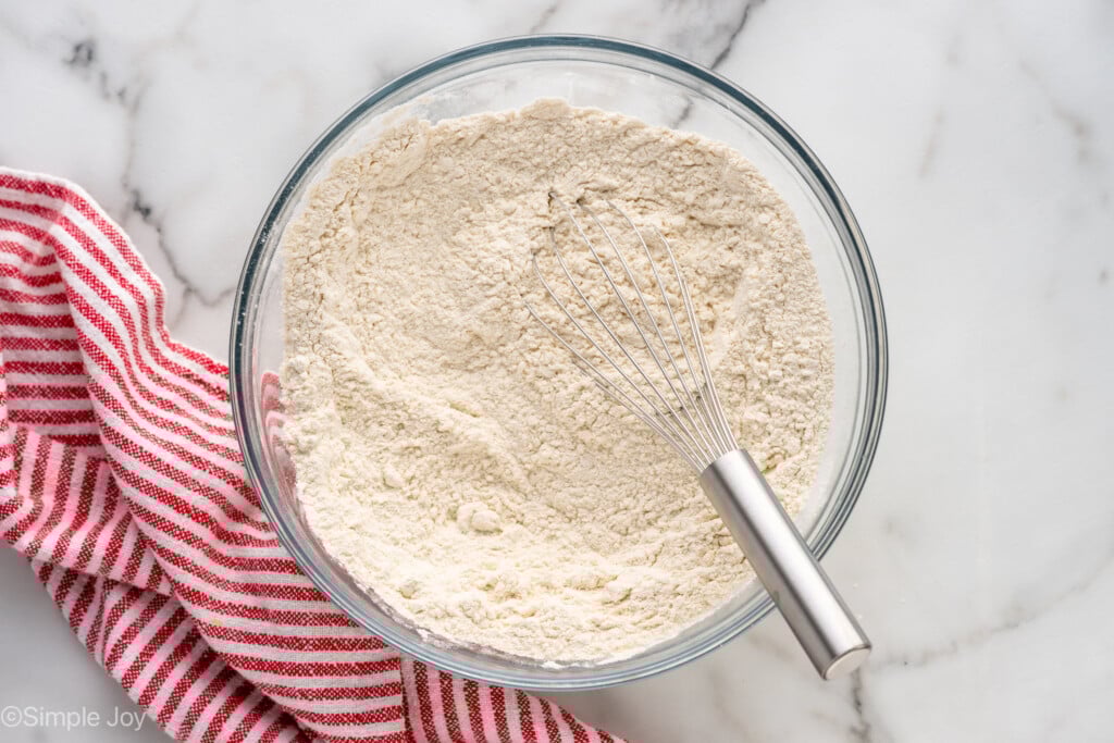 Overhead view of a mixing bowl of ingredients for Self Rising Flour recipe with whisk - 6