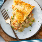Pinterest graphic for Chicken Pot Pie recipe. Image shows overhead view of a slice of Chicken Pot Pie on a plate with a fork. Text says, "Chicken Pot Pie simplejoy.com."
