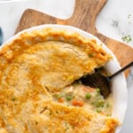 Pinterest graphic for Chicken Pot Pie recipe. Text says, "the best Chicken Pot Pie simplejoy.com." Image shows overhead view of Chicken Pot Pie with piece removed, serving spatula in pan.