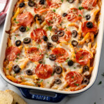 Pinterest graphic for Pizza Casserole recipe. Image shows a baking dish of Pizza Casserole topped with black olives and pepperoni. Text says, "super easy Pizza Casserole simplejoy.com."