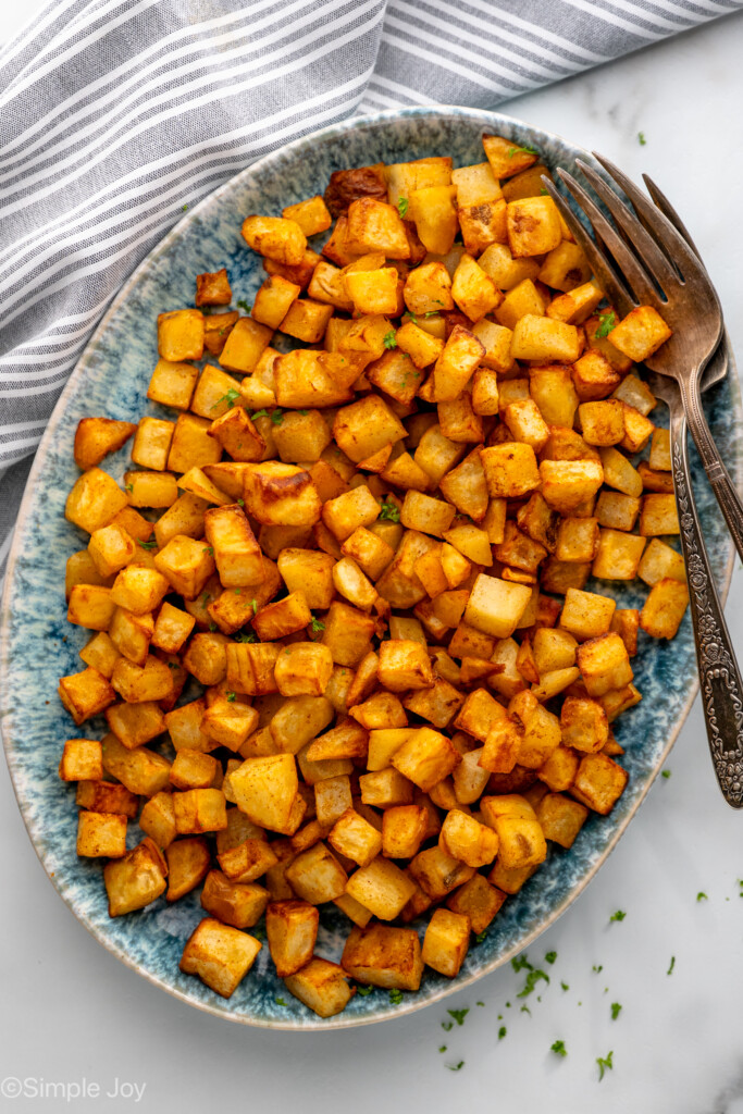 Overhead view of a platter of Air Fryer Breakfast Potatoes with forks