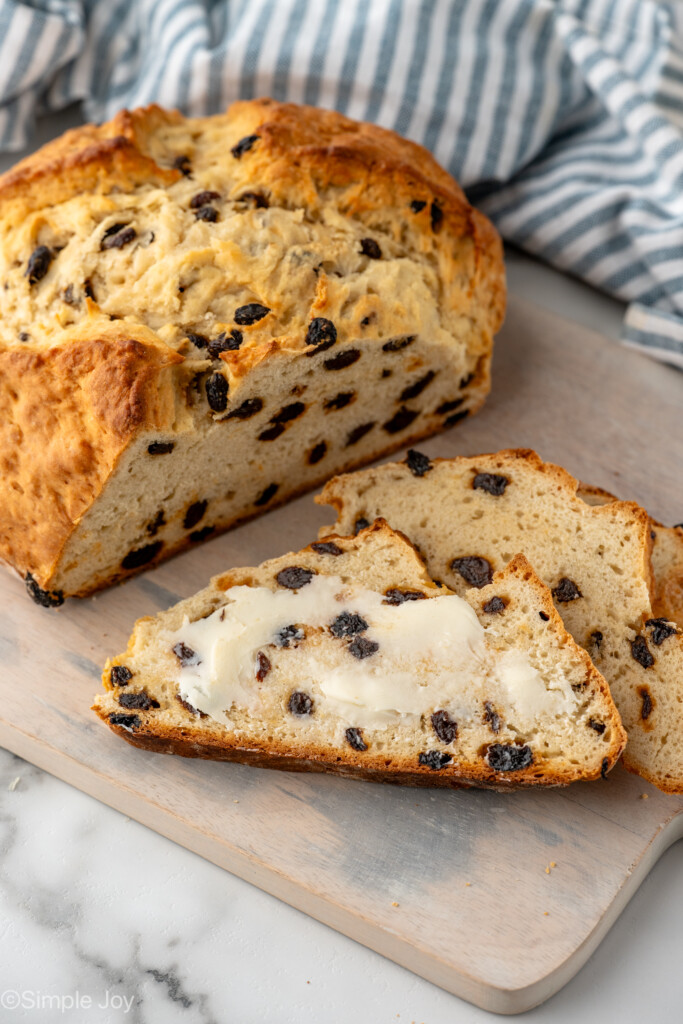 Loaf of Irish Soda Bread with two slices beside, topped with butter