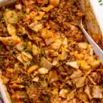 Overhead view of a baking dish of cabbage roll casserole with a spoon for serving