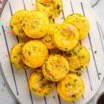 Overhead view of a platter of Cottage Cheese Egg Bites topped with herbs