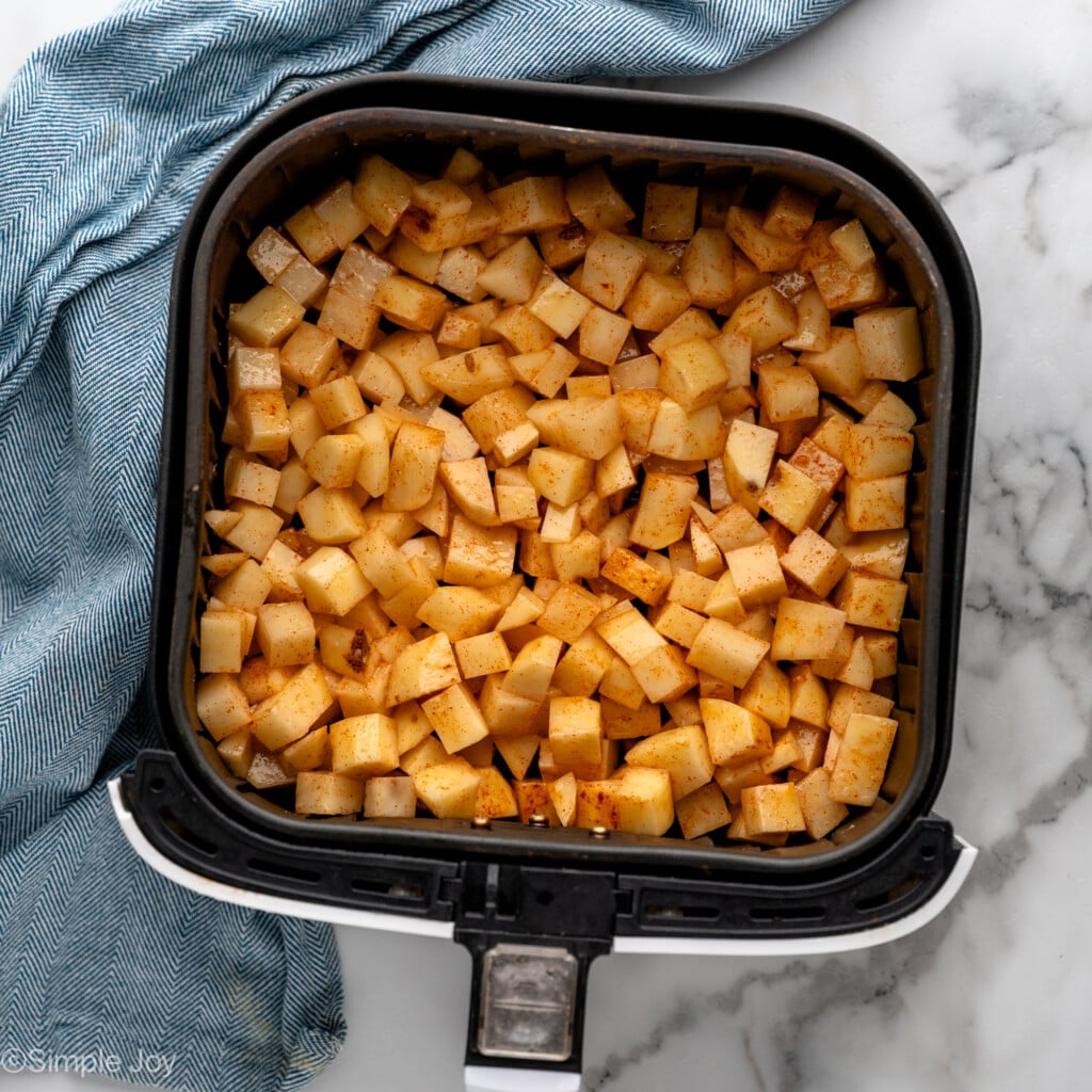 Overhead view of air fryer basket with Air Fryer Breakfast Potatoes recipe before cooking
