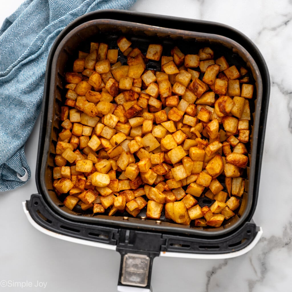 Overhead view of air fryer basket with Air Fryer Breakfast Potatoes recipe after cooking
