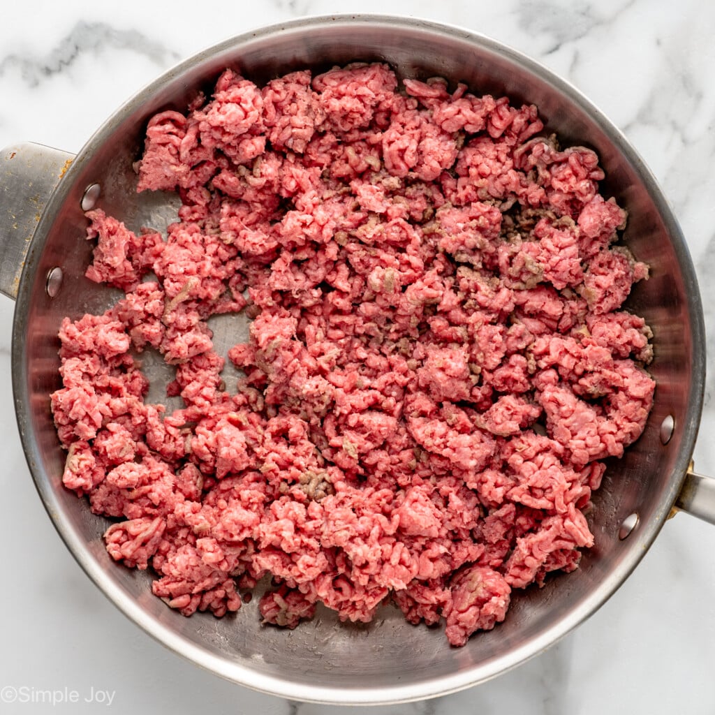 Overhead view of a skillet of ground beef cooking for cabbage roll casserole recipe