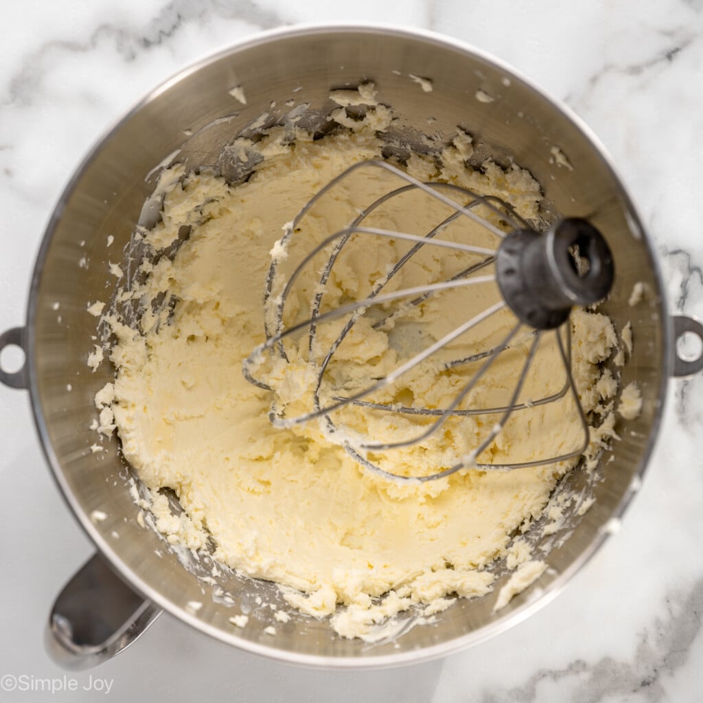 Overhead view of mixing bowl and beaters with frosting for Carrot Cake Cupcakes recipe
