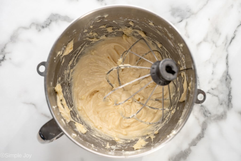 Overhead view of mixing bowl and beaters with frosting for Carrot Cake Cupcakes recipe