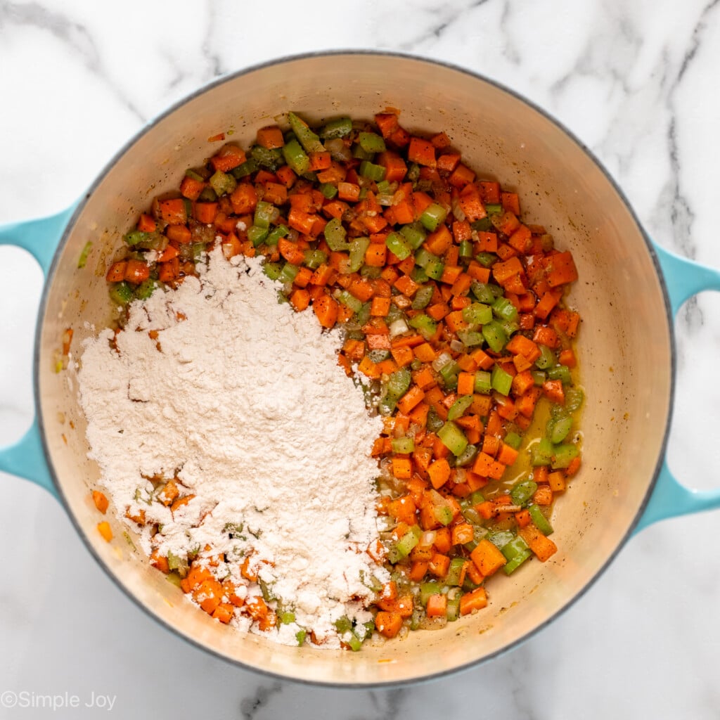 Overhead view of a pot of chopped vegetables, seasonings, and flour for Chicken Pot Pie recipe