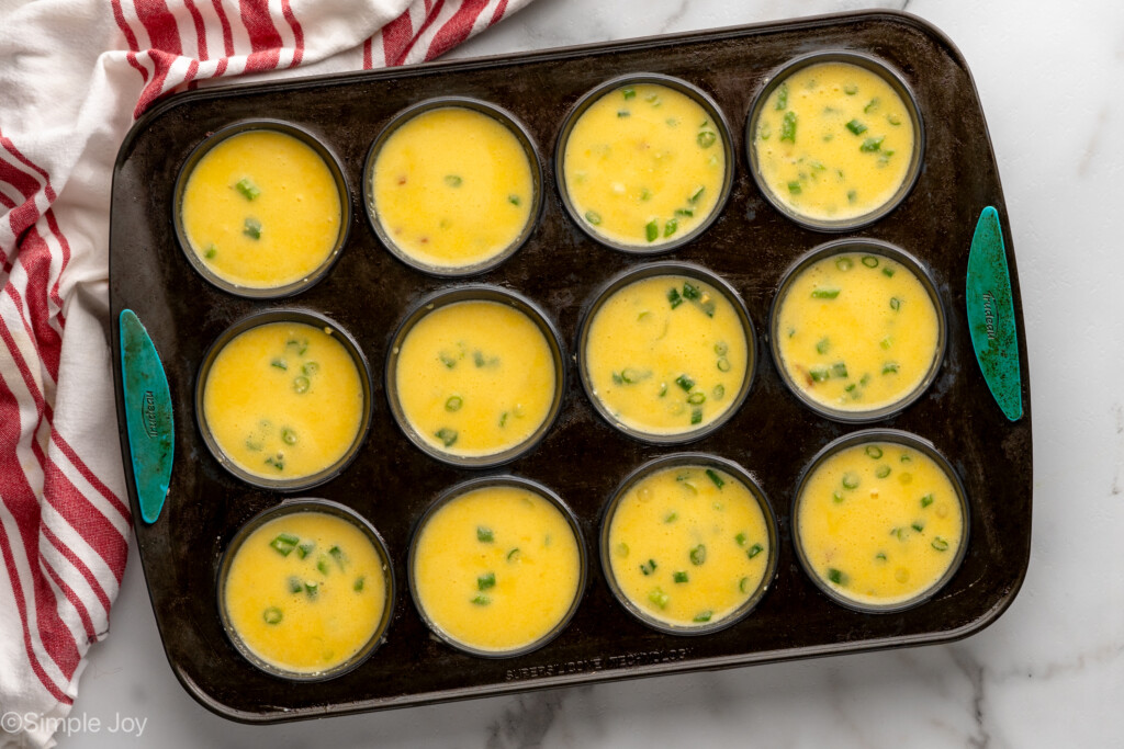 Overhead view of a muffin pan with Cottage Cheese Egg Bites recipe before baking