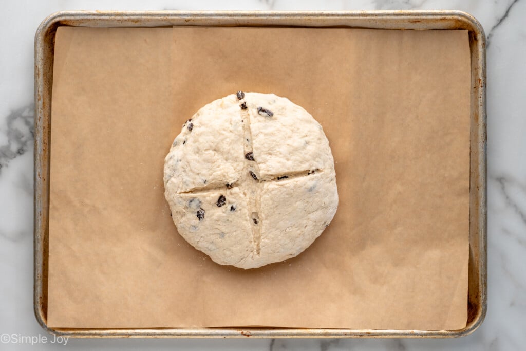 Overhead view of loaf of Irish Soda Bread on baking sheet before baking