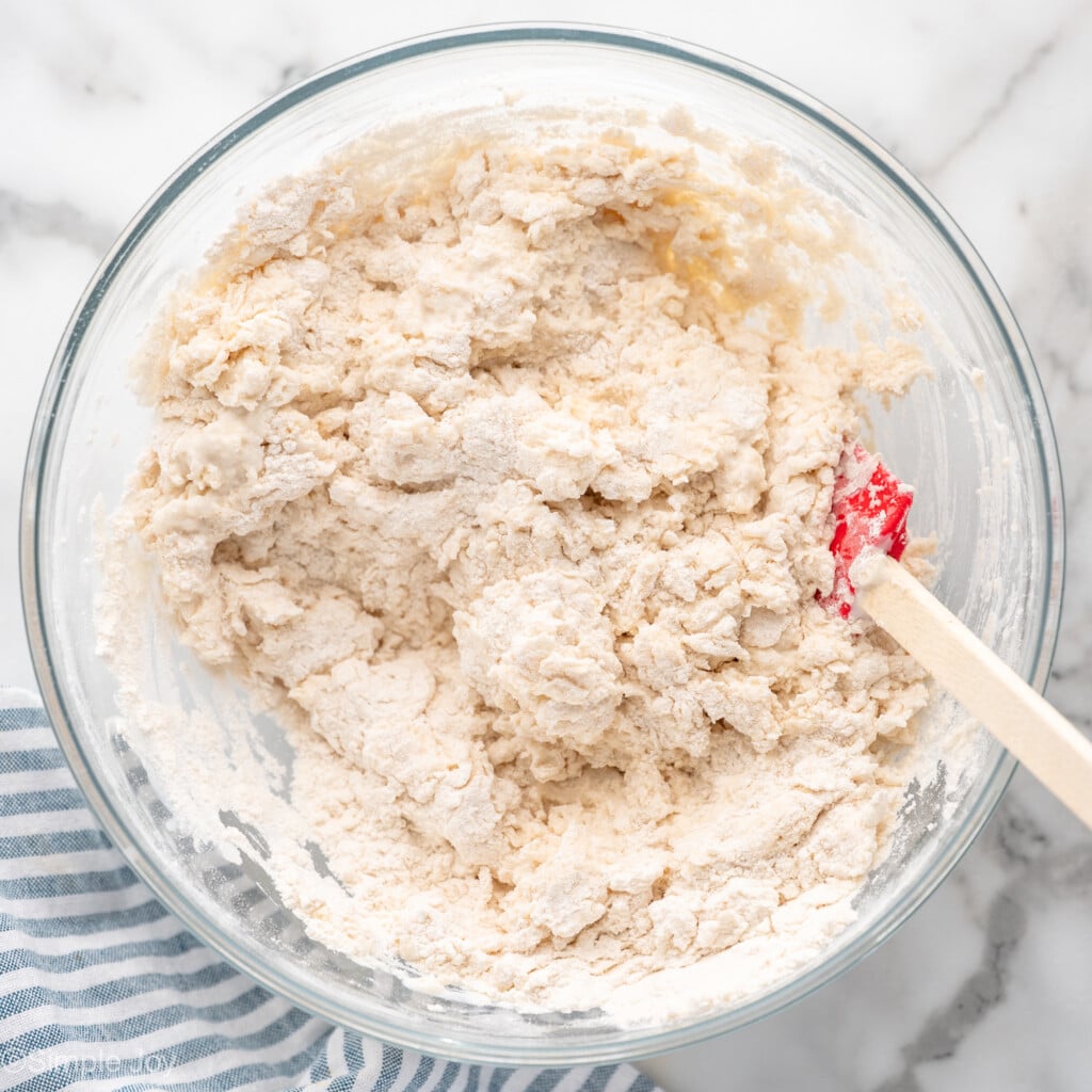 Overhead view of a mixing bowl of ingredients with spatula for Irish Soda Bread recipe