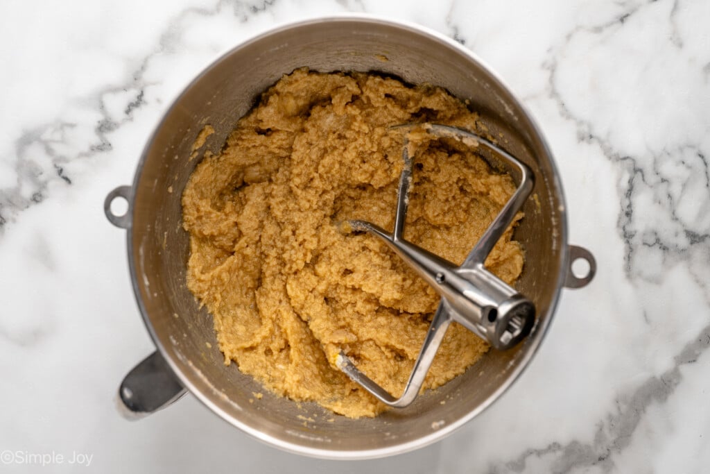 Overhead view of mixing bowl of ingredients mixed with beaters for Oatmeal Raisin Cookies recipe