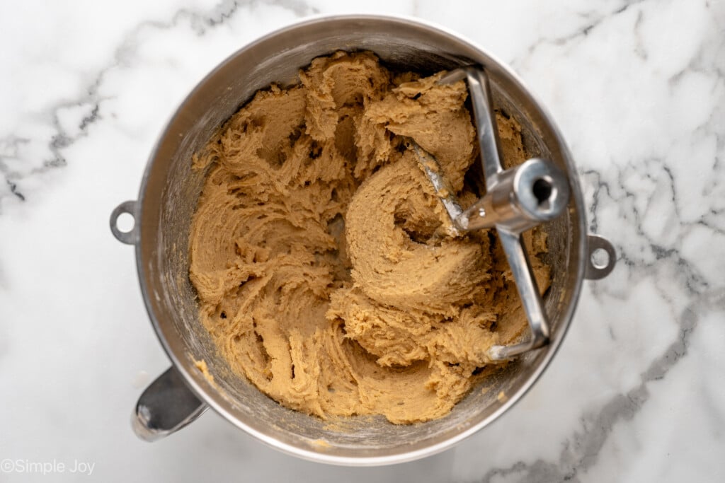 Overhead view of mixing bowl of ingredients mixed with beaters for Oatmeal Raisin Cookies recipe