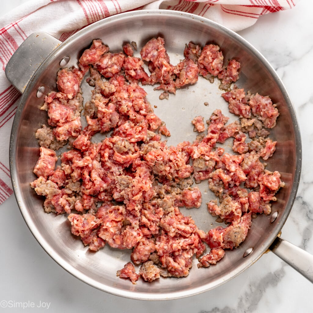 overhead of skillet with partially cooked sausage